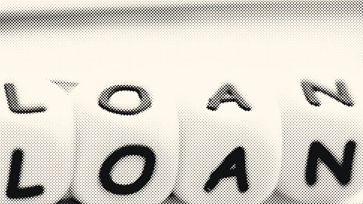 White letter cubes spelling LOAN, resting on a form held by a clipboard